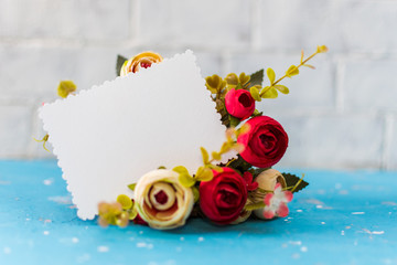 empty greeting card on the background of a bouquet of flowers