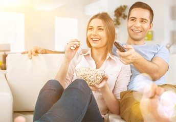 Young couple watching TV at home