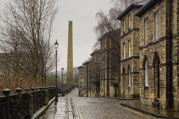 Albert Terrace, Saltaire, Yorkshire is an iconic Victorian street scene with its cobbled street, workers' houses and mill chimney, a resource often used by film makers seeking authentic scenery