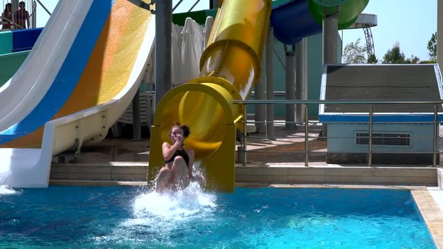 Young woman riding down a water chute at speed