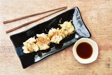 steamed Chinese dumpling stabbing minced pork or dim sum dipping soy sauce on plate