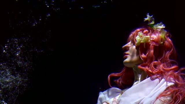 oceanic naiad is floating inside depth in night, woman dressed like fairytale character, close-up