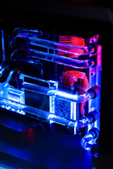 Inside a high performance computer. Computer circuit board and CPU cooling fans illuminated by...