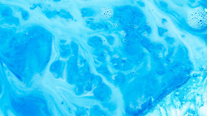 Abstract blue paint background. Color gradient fluid flowing similar to river system covering rough uneven glitter surface.