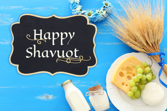 top view photo of dairy products over blue wooden background. Symbols of jewish holiday - Shavuot