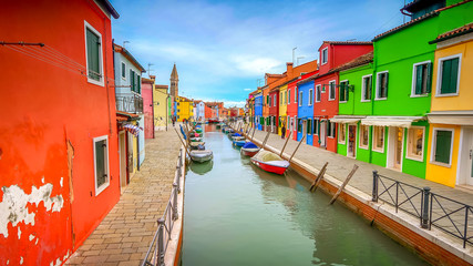 Colorful fisherman's homes dot either side of a canal  in the village of Burano in Venice, Italy