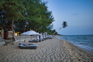Sunbeds with parasol on a nice Long beach in the evening, surrounded by palm trees in Phu Quoc, Vietnam