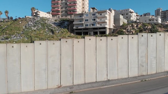 Flying close to security fence in Jerusalem Drone flight view of east Jerusalem security wall divide between Israeli and Arab neighborhood   Anata and pisgat zeev, israel