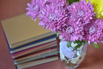 bouquet of flowers in vase with books nearby