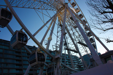 a high Ferris wheel in contrast to the blue sky
