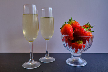 First flavored delicious sweet strawberries with two glasses with white wine 
