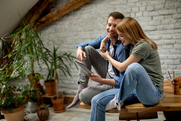 Young couple is using a digital tablet and smiling in kitchen at home