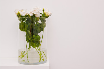 White eustoma flowers in glass on white background