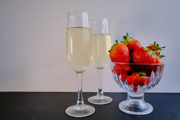 First flavored delicious sweet strawberries with two glasses with white wine 