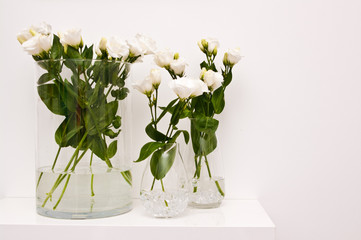 White eustoma flowers in glass on white background