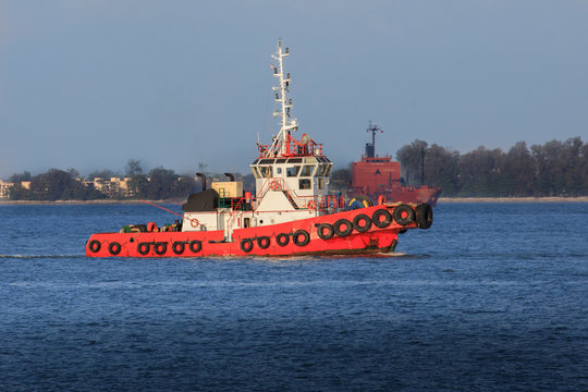 Roter Schlepper an der K&uuml;ste auf dem Weg in den Hafen