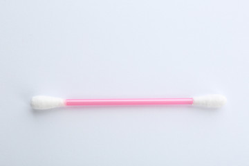 Pink plastic cotton swab on white background