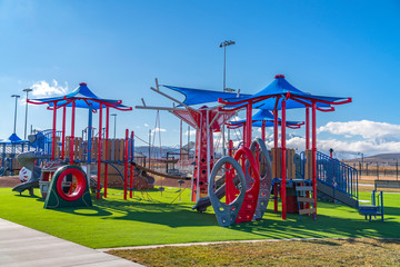 Colorful playground for children casting shadows on the lawn on a sunny day