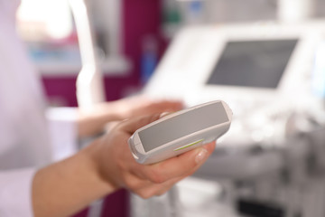 Sonographer holding ultrasound machine probe in clinic, closeup