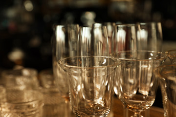 Different empty clean glasses in bar, closeup