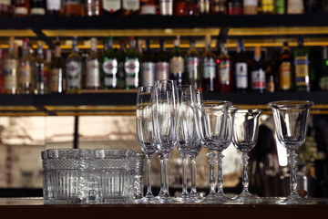 Different empty clean glasses on counter in bar