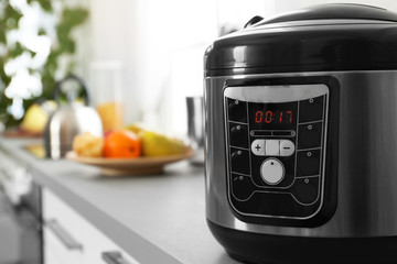 Modern multi cooker on table, closeup. Space for text