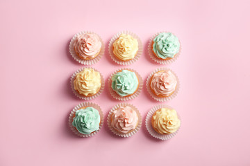 Flat lay composition with delicious cupcakes on color background