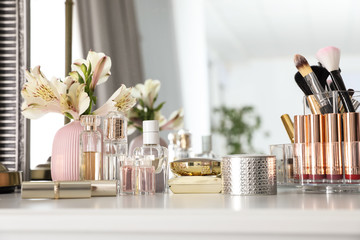 Luxury makeup products and accessories with perfumes on dressing table