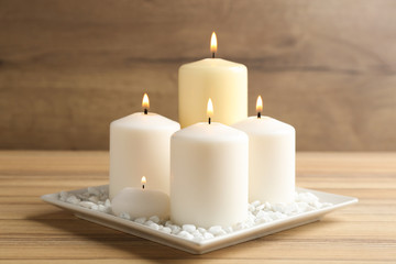 Composition with burning candles on wooden table