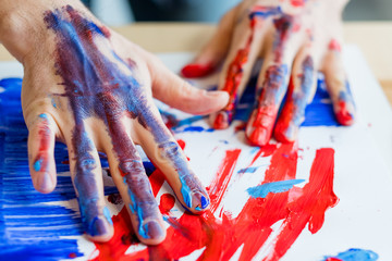 Man hands in red blue paint closeup. Fingers, paper smeared with acrylic oil gouache. Art therapy. Activity and creativity.