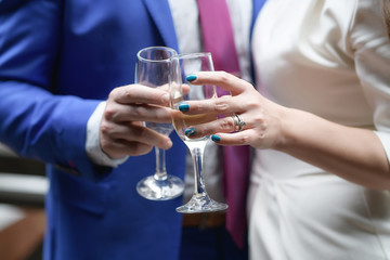 Cropped shot of a man and a woman holding champagne flutes and toasting, concept of couple celebrating, a wedding toast, friends or colleagues night out, or societal acceptance of occasional drinking