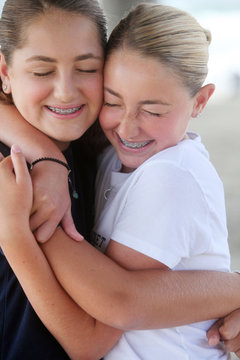 Sisters Hugging Tightly With Closed Eyes