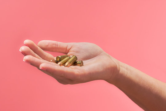 Woman's hand holding bullets for a gun