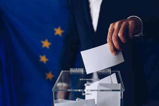 EU elections. Man throwing his vote into the ballot box.