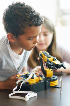 Young boy learning how to control a robot