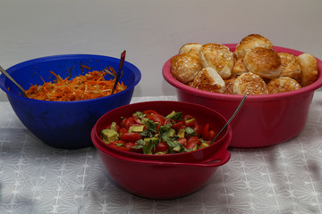 Salads with fresh rolls stand on the table