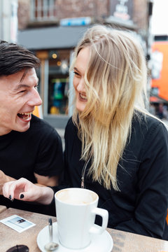Young Couple at the Coffee Shop Drinking a Cappuccino