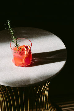 Short alcoholic drink made from the juice of blood oranges, garnished with rosemary.