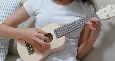 Woman play ukulele with a song