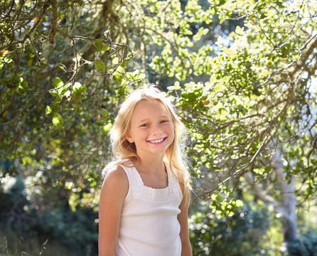 Portrait of little girl with blonde hair outdoors
