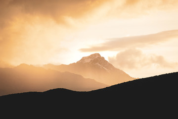 Montagne dans la brume éclairée par le soleil couchant