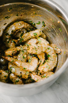 Closeup of marinated shrimp in a stainless bowl
