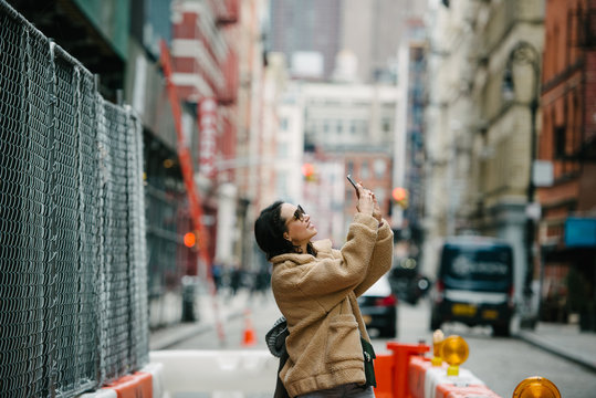 Woman taking photo with phone in the city