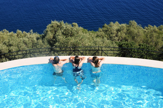 three kids in swimming pool on holiday