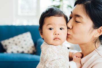 Adorable baby girl and her mother playing at home