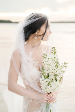 Wonderful bride in veil with floral bouquet