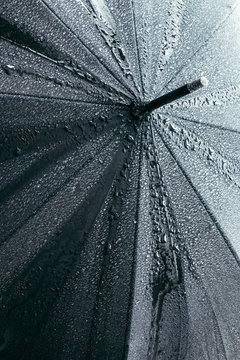 Black umbrella under heavy rain