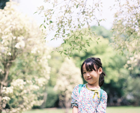 Asian girl smiling standing under the tree in the park.shot by 120 films