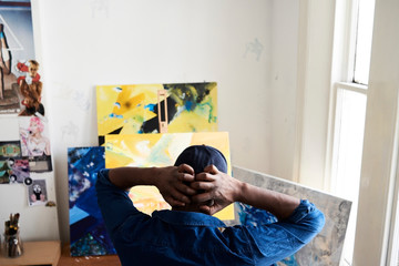 Stressed young painter assessing art work at studio.