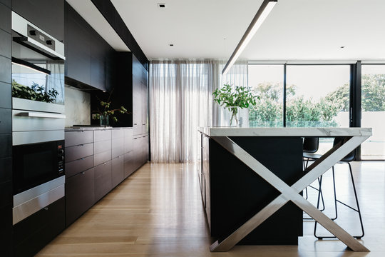 Stunning black designer kitchen with large glass sliding doors